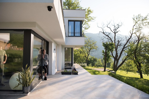 portrait of a young beautiful successful woman in the doorway of her luxury home villa