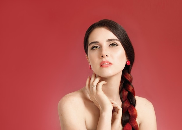 Portrait of a young beautiful wellgroomed halfnaked tender woman on a coral background look at amera