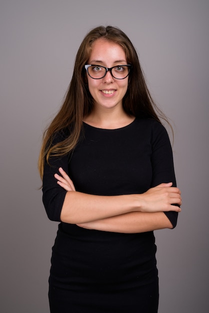 Portrait of young beautiful woman against gray background