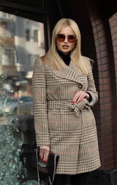 Portrait of young beautiful woman in autumn coat. Fashion photo.