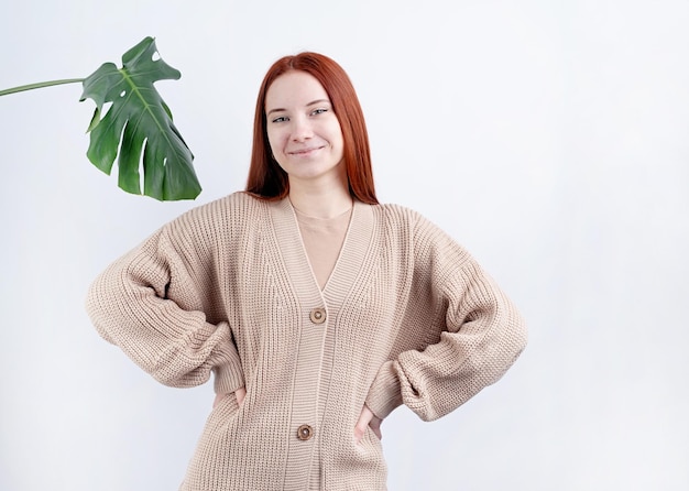 Portrait of a young beautiful woman in beigeclothes posing on white background copy space