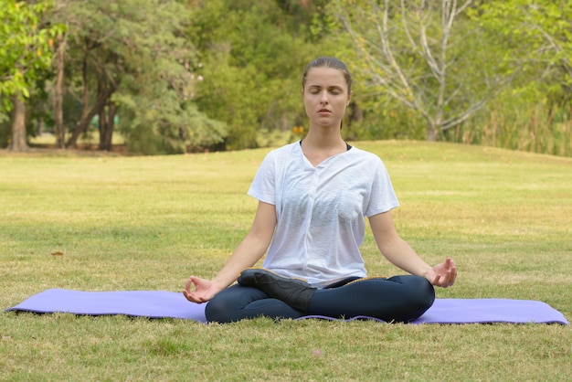 Portrait of young beautiful woman exercising at the park outdoors