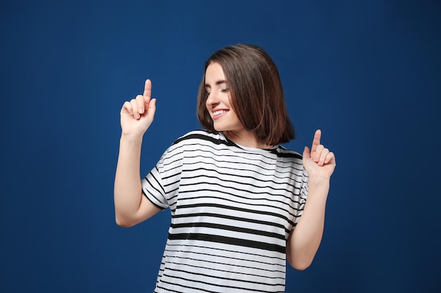 Portrait of young beautiful woman smiling on color background