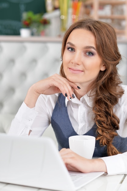 Portrait of a young beautiful woman using laptop