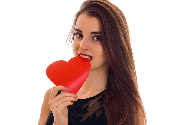 Portrait of young beautiful woman with red heart isolated on white wall