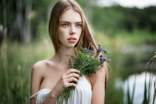 Portrait of Young beautiful woman with wild flowers