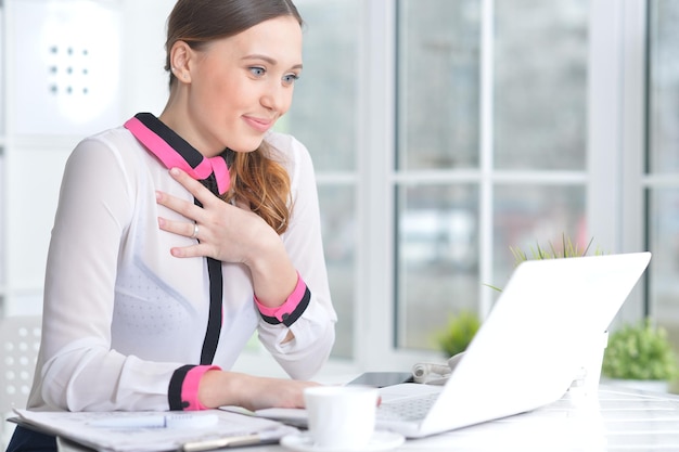 Portrait of young beautiful woman working with laptop in modern office