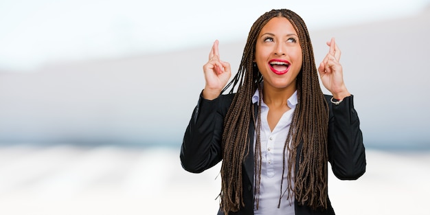 Portrait of a young black business woman crossing his fingers