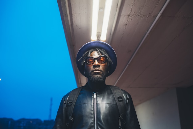 Portrait of young black man standing in the street and looking camera 