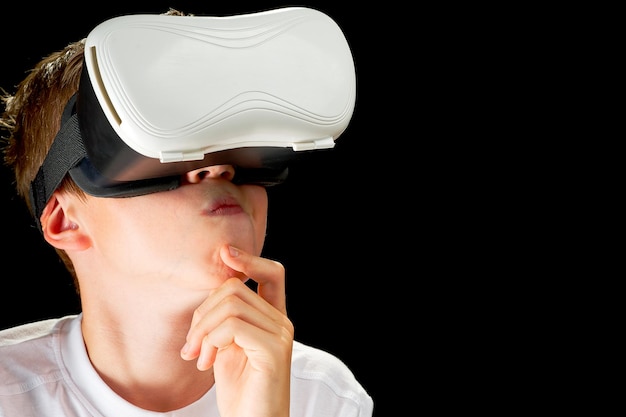 Portrait of young boy playing VR game in black background Young hipster wearing VR headse