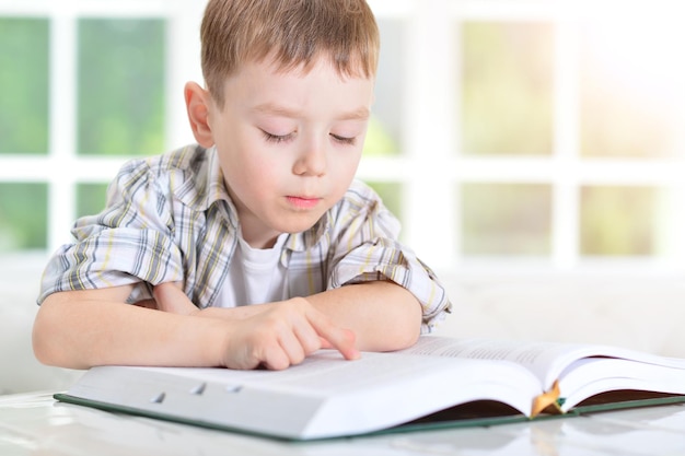 Portrait of a young boy wearing glasses doing homework