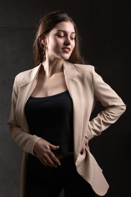 Portrait of a young brunette with long hair in the studio Dramatic photo in dark colors