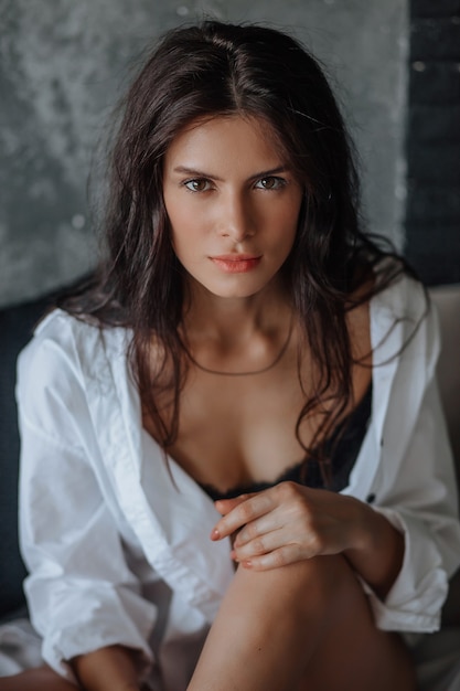 Portrait of young brunette woman on a light background