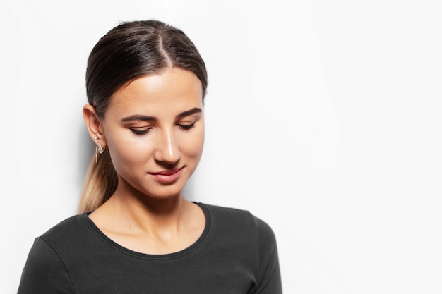 Portrait of young brunette woman looking down.