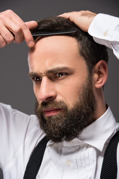 Portrait of a young brutal bearded man with straight razor.