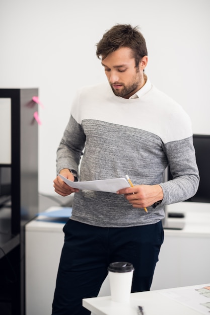 A portrait of a young business man analyze some document in his office