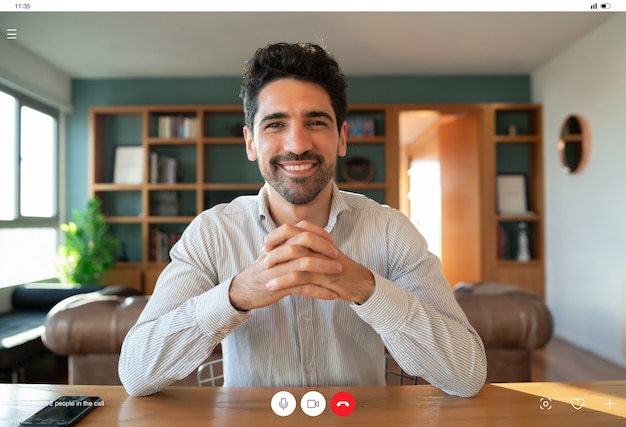 Portrait of young business man on a work video call while staying at home