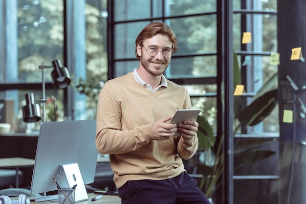 Portrait of young businessman businessman man blond smiling and looking at camera at work in modern