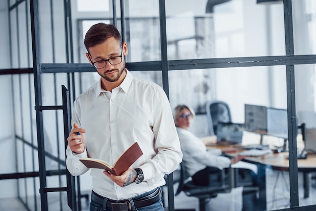 Portrait of young businessman in formal clothes that stands in office.