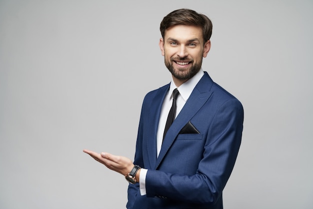 Portrait of a young businessman pointing on a blank space with his finger