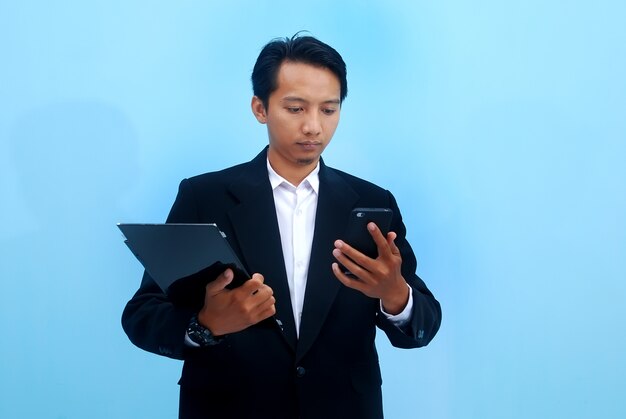 portrait of a young businessmen looking at the development of his business through tabs and smartphones