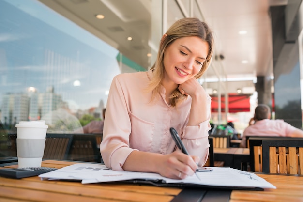 Portrait of young businesswoman checking paperwork and working at coffee shop.coffee shop. Business concept.