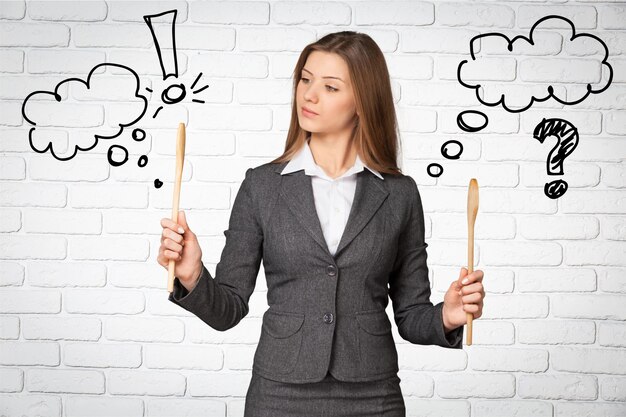 Portrait of young businesswoman holding wooden spoons