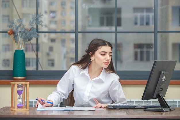 Portrait of a young businesswoman sitting at the desk and looking at her pc High quality photo