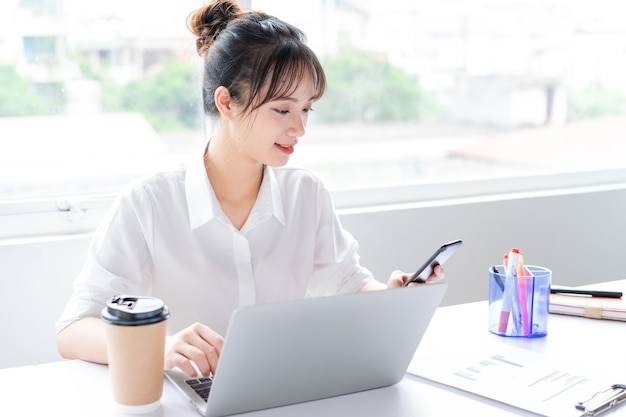 Portrait of young businesswoman sitting and using phone