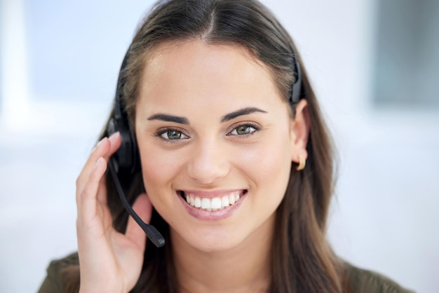 Portrait of a young businesswoman using a headset in a modern office