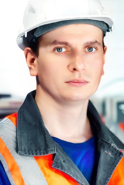 Portrait of young Caucasian engineer in white helmet and protective vest Gas industry worker at production facility