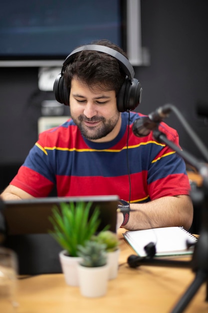 Portrait of young caucasian male radio presenter or podcaster working in recording studio