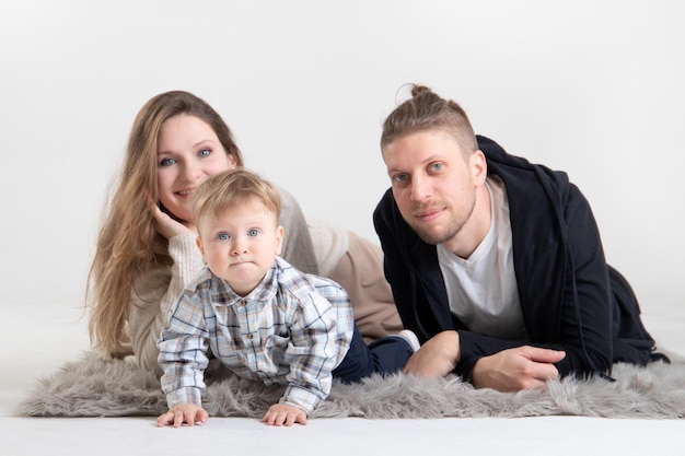 Portrait of young caucasian parents with little curious baby