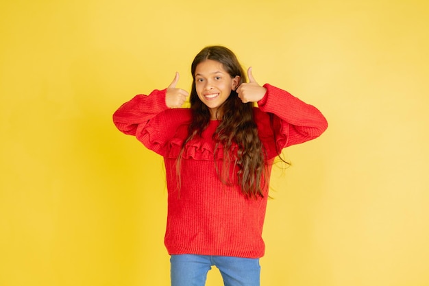 Portrait of young caucasian teen girl with bright emotions isolated on yellow