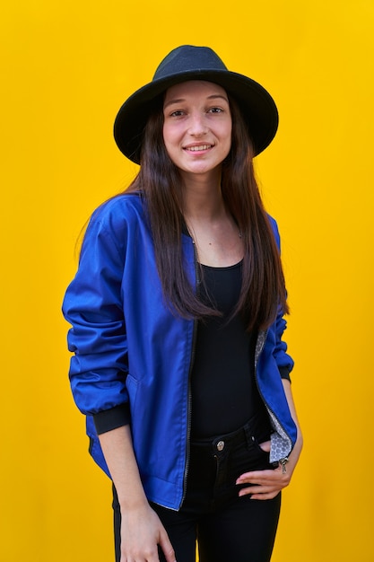 Portrait of a young Caucasian woman in black hat and blue jacket.