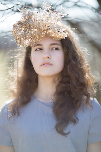 Portrait of a young caucasian woman. Happy beautiful curly girl close-up, wind fluttering hair. Spring portrait outdoors.