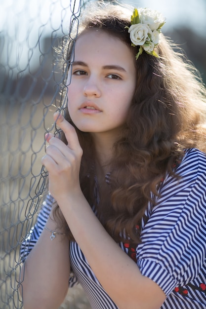 Portrait of a young caucasian woman. Happy beautiful curly girl close-up, wind fluttering hair. Spring portrait outdoors.