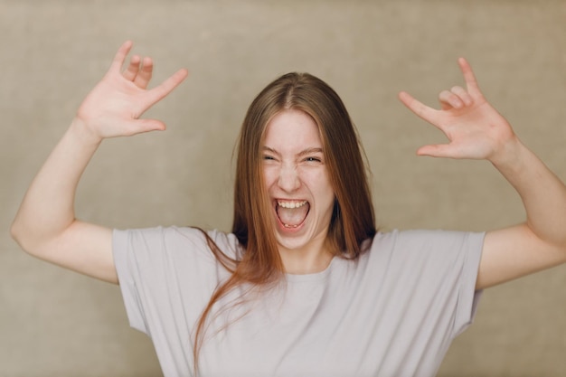 Portrait of young caucasian woman looking at camera against beige background