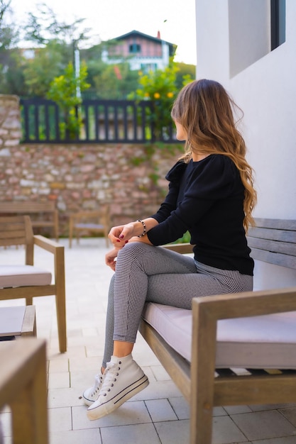 Portrait of a young Caucasian woman sitting on the terrace of a restaurant