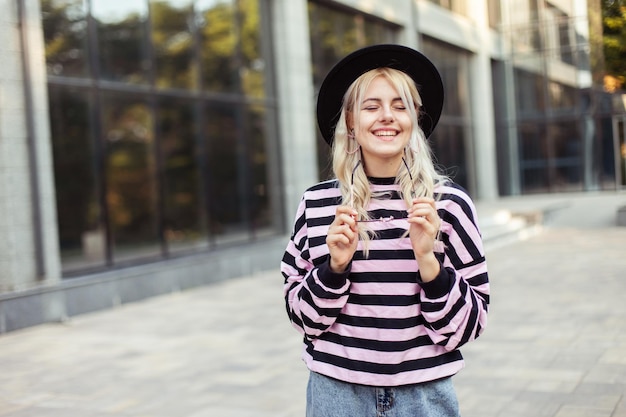 Portrait of young charming woman in a sweater and hat outdoors