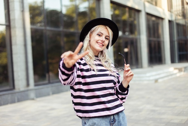 Portrait of young charming woman in a sweater and hat outdoors