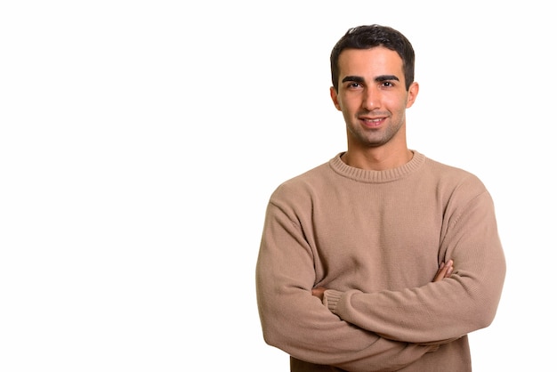 Portrait of young confident Persian man against white wall