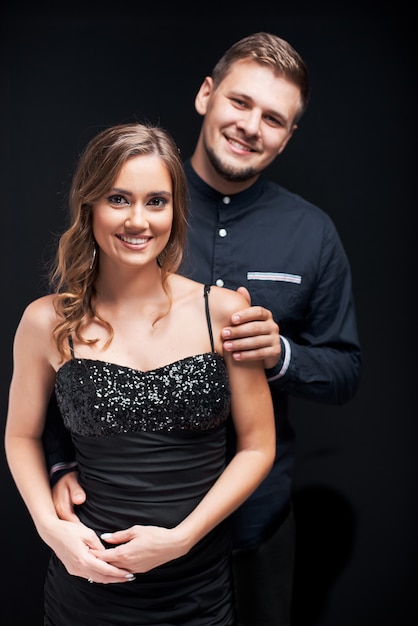 Portrait of young couple in elegant evening clothes isolated on black 