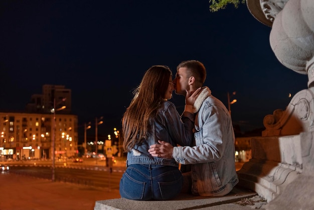 Portrait of young couple hugs and kiss on background of the evening city Date in the city