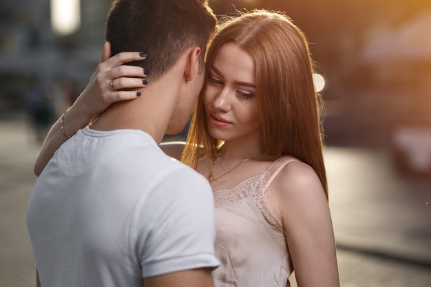 Portrait of young couple in love, enjoying the sunset in city.