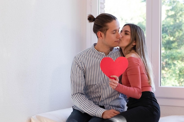 Portrait of a young couple in love holding a red heart