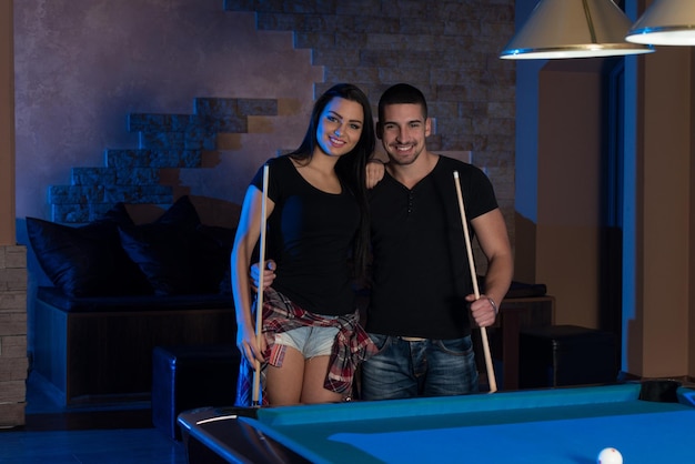 Portrait Of A Young Couple Playing Billiards