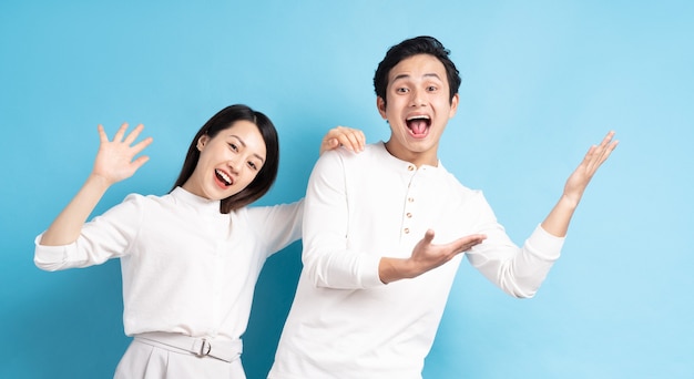 Portrait of young couple standing posing against blue wall