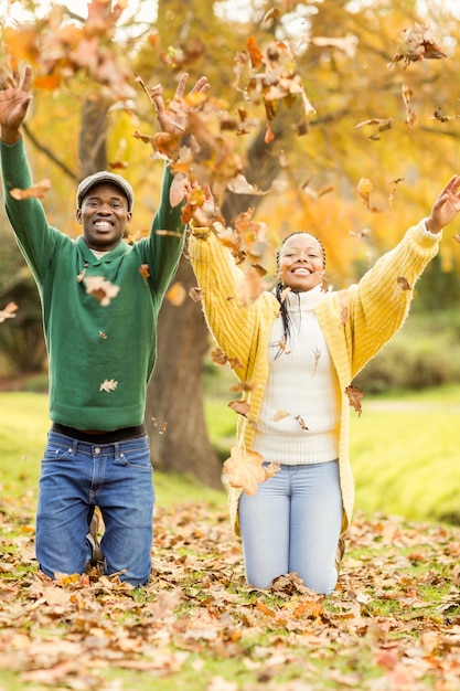 Portrait of a young couple throwing leaves around