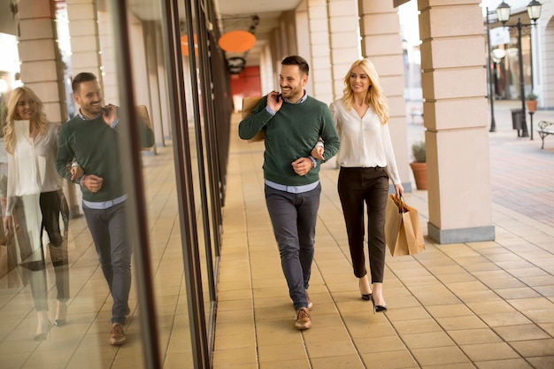 Portrait of young couple with shopping bags in city